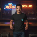 Bar patron wearing a branded t-shirt inside a neighborhood bar with neon signage and a warm, inviting atmosphere
